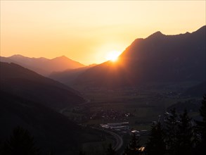Sunset over mountain peak, in the valley the village Traboch, Schoberpass federal road, view from