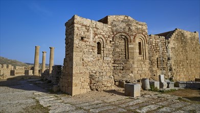 St John's Chapel, ruins of an ancient structure with columns and an arch under a clear blue sky, St