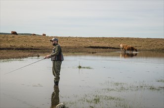 Sport fisherman fishing in lake on cloudy day, Cambara do sul, Rio Grande do sul, Brazil, South