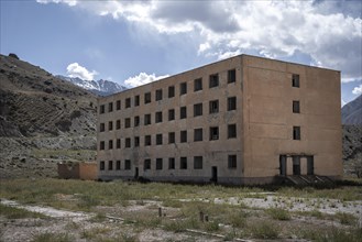 Abandoned buildings in a barren landscape, ghost town of Enilchek in the Tien Shan Mountains,