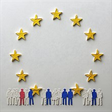 Conceptual representation of a group of paper figures surrounded by EU stars, AI generated
