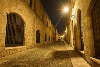 An old cobbled street at night, illuminated by street lamps creating a warm atmosphere, Knights