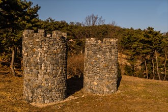 Two stone structures resembling castle towers at public mountain park on sunny day in Yesan, South