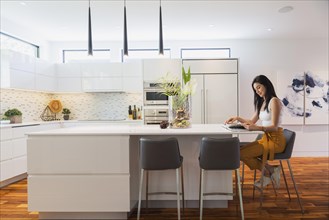 Interior designer Liza Castro in her kitchen with white high-gloss lacquered cabinets and island