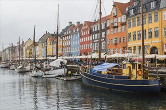 Colourful 17th century apartment buildings and houses with moored sailboats along the Nyhavn canal,