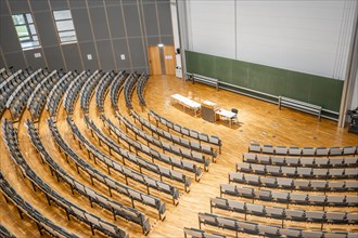 View from above into an empty lecture theatre with rows of seats and lectern, interior photo,