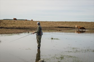 Sport fisherman fishing in lake on cloudy day, Cambara do sul, Rio Grande do sul, Brazil, South