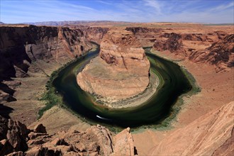 Sunlit view of Horseshoe Bend with striking river bend and red rock formations, Horseshoe Bend,