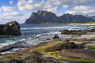 Seascape on the beach at Uttakleiv (Utakleiv), rocks and green seaweed in the foreground. In the