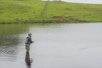 Black bass fisherman fishing inside lake, Cambara do sul, Rio Grande do sul, Brazil, South America