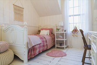 Single bed with red, pink and grey tartan bedspread, white painted antique style wooden headboard