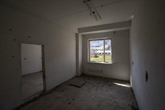 An abandoned, dilapidated room with a view of the mountains through the window, ghost town,