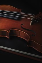 Detailed view of a violin focussed on the strings and body structure