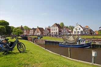 Picturesque cutter harbour, Greetsiel, ebikes, gabled houses, Krummhoern, East Frisia, Germany,