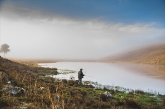 Sport fisherman fishing in lake on cloudy day, Cambara do sul, Rio Grande do sul, Brazil, South