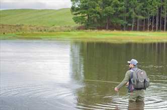 Black bass fisherman fishing inside lake, Cambara do sul, Rio Grande do sul, Brazil, South America