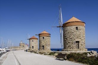 Windmills on the pier at Mandraki harbour, Rhodes Town, Rhodes, Dodecanese, Greece, Europe