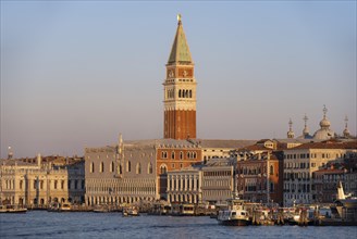 Campanile bell tower and Doge's Palace at sunrise, view from the promenade over the water, Venice,