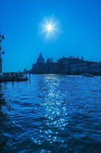 Silhouetted view of Grand canal with water taxis, Santa Maria della Salute basilica and Renaissance