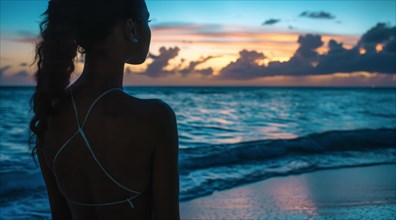 A beautiful woman walks on the beach at sunset during dream vacation near the ocean, AI generated