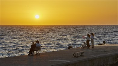 People relaxing on the shore and enjoying the sunset over the sea, dusk, sunset, Western Promenade,