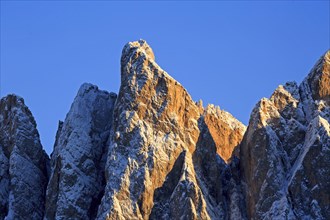 Mountain peaks illuminated by the setting sun with a clear blue sky, Italy, Trentino-Alto Adige,