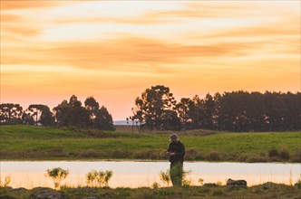 Sport fisherman fishing in lake on cloudy day, Cambara do sul, Rio Grande do sul, Brazil, South