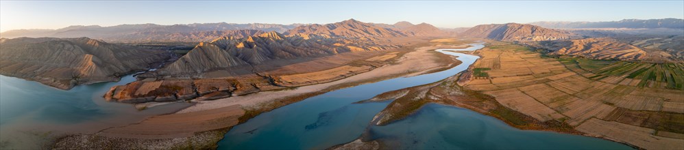 Panorama, Naryn river between mountains and fields, at Toktogul reservoir at sunset, aerial view,