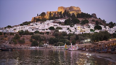 Evening view of a Greek village with ancient castle above the sea, Paulus Bay, below the Acropolis