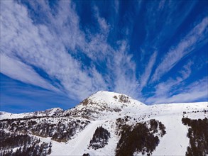 Dynamic sky over a snowy mountain peak in the alpine landscape, Grau Roig, Encamp, Andorra,