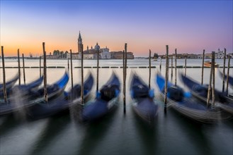 Venetian gondolas, boat dock at St Mark's Square, church of San Giorgio Maggiore in the background,