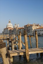Trinita pier and mooring posts on Grand Canal with Renaissance architectural style palace buildings