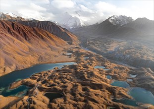 Atmospheric aerial view, high mountain landscape with glacier moraines and mountain lakes, behind