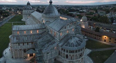 View of the illuminated Cathedral of Santa Maria Assunta with several domes at dusk with an
