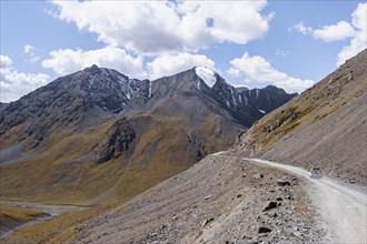 Off-road car on mountain pass, gravel road in the mountains in the Tien Shan, Engilchek Valley,