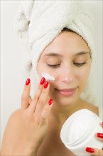 Hydration. Cream smear. Beuaty close up portrait of young woman with a healthy glowing skin is