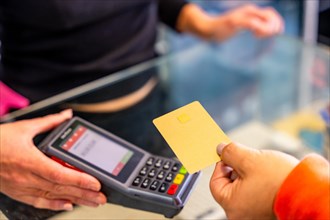 Close-up of an unrecognizable woman paying the bill of a hair salon using contact less card