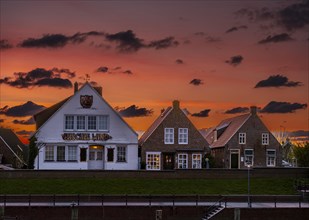 Historic houses at Greetsiel harbour at sunset, Greetsiel, Krummhoern, East Frisia, Lower Saxony,