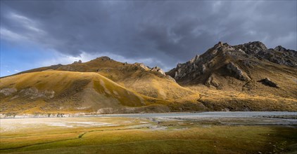 Mountain valley with Sary Jaz river in the evening light, autumn mountains with yellow grass, Tien