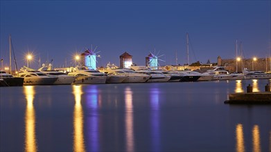 Lively marina at night with illuminated windmills and reflections in the water, twilight, Mandraki