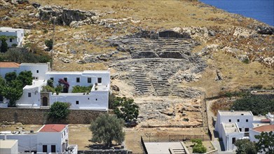 Ruins of an ancient theatre near white Greek village houses, Lindos, Rhodes, Dodecanese, Greek
