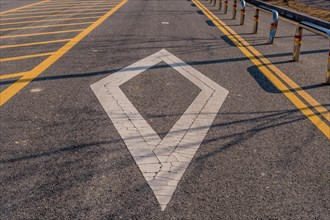 White diamond shape painted on pavement between two yellow lines in South Korea