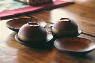 Traditional Asian tea ceremony setup with bowls on wooden table