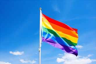 Rainbow colored LGTB flag in front of blue sky. KI generiert, generiert, AI generated