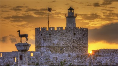 A statue on the top of a fortress wall with a golden sunrise, sunrise, dawn, Fort of Saint