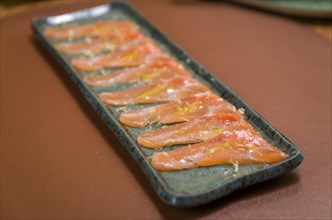 Delicious premium salmon sashimi arranged on an elegant handmade platter