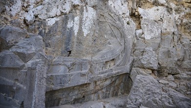 At the entrance to the Acropolis, The ruins of an ancient stone structure embedded in a natural