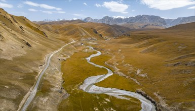 Aerial view, Kol Suu River winds through a mountain valley with hills of yellow grass, Naryn
