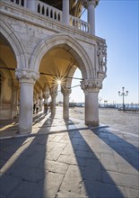 Colonnade of the Doge's Palace with Sun Star in the Piazetta San Marco, St Mark's Square, Venice,