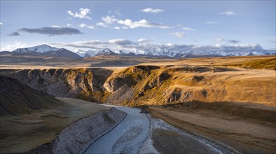 Mountain valley with Sary Jaz River in the morning light, high glaciated mountain peaks of the Tien
